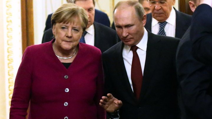 Była kanclerz Niemiec Angela Merkel i Prezydent Rosji Władimir Putin wchodzą do sali podczas wspólnej konferencji prasowej na Kremlu, 11 stycznia 2020 r.