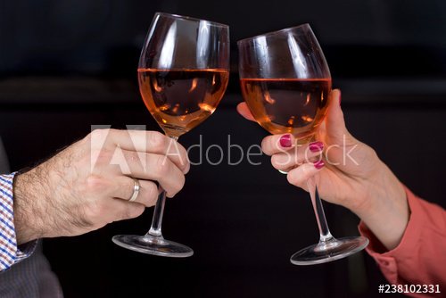 Dłonie kobiety i mężczyzny z kieliszkami do wina w dłoniach wznoszą toast.  Kieliszki z winem na ciemnym tle. - Buy this stock photo and explore  similar images at Adobe Stock | Adobe Stock